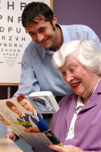 Woman being shown how to use a magnifier